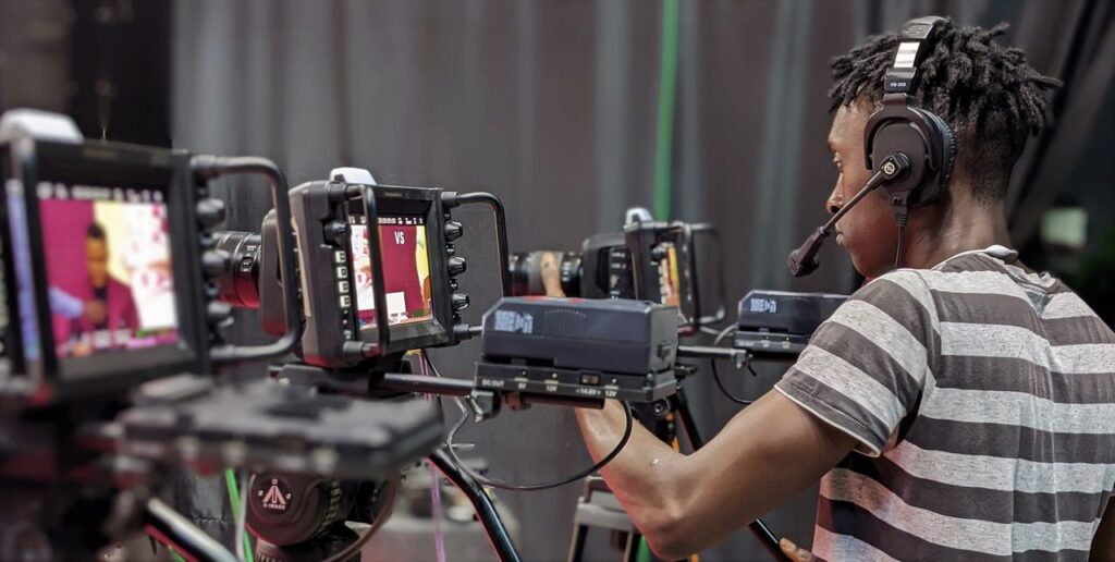 Mastering the First Impression: Your intriguing post title goes here A videographer adjusts camera equipment during a live broadcast in a studio setting.