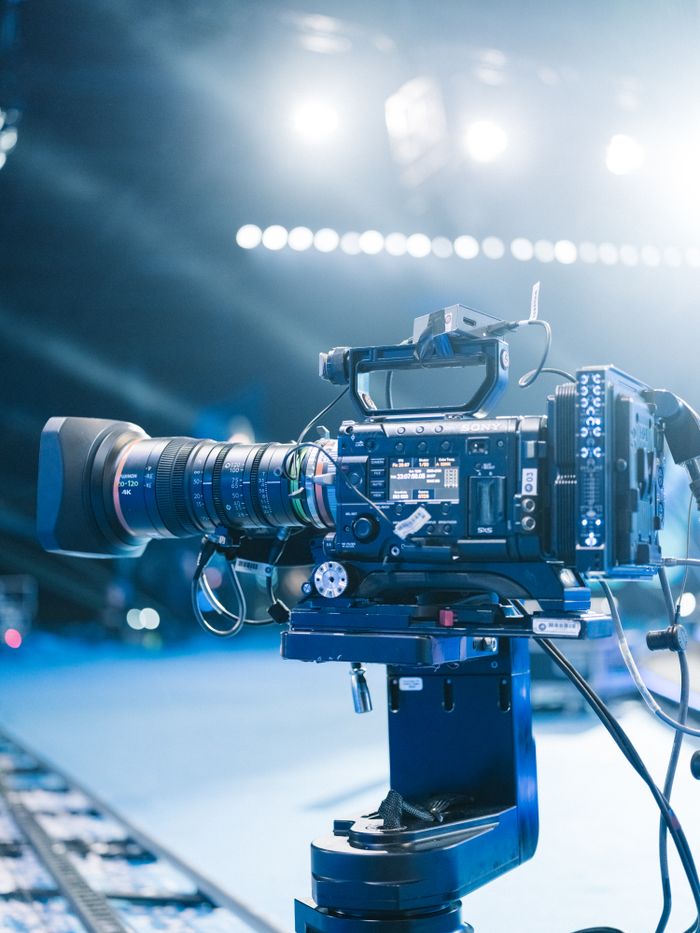 High-end professional video camera setup for filming on set with bright stage lights.